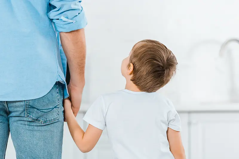 Back View of a father and son reuniting in Georgetown TX from parent alienation.