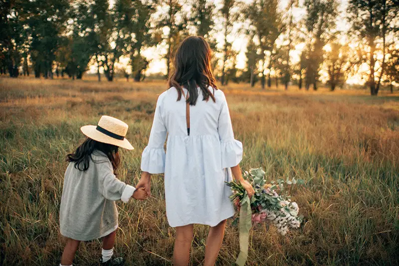 Mother and Daughter walking in a field together after wining their case with The Eggleston Law Firm